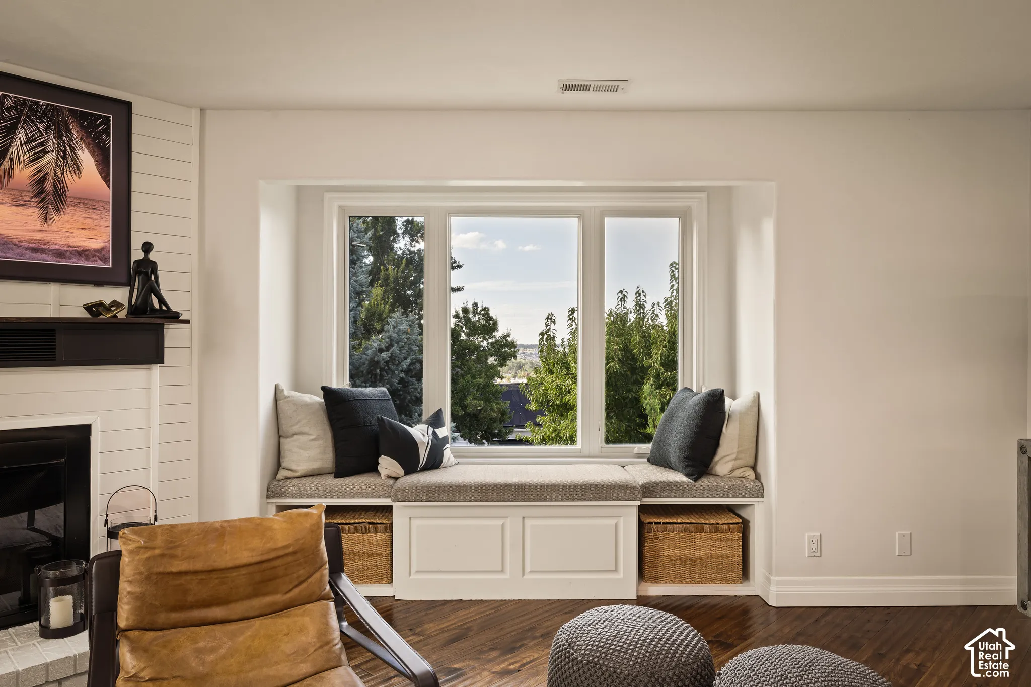 Window seat with built-in storage, wood-finish flooring, and white trim