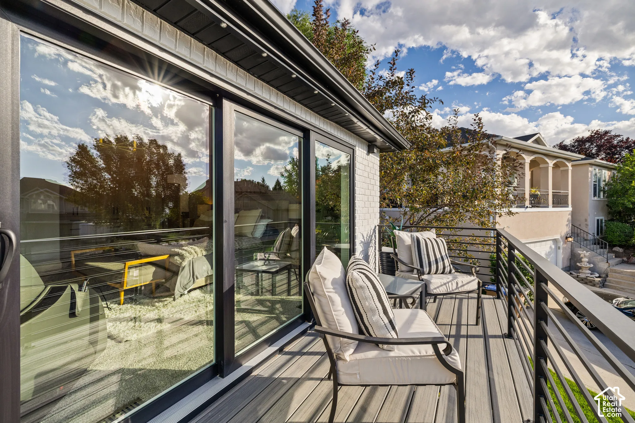 Expansive outdoor deck featuring composite decking, black metal railings, and large sliding glass doors