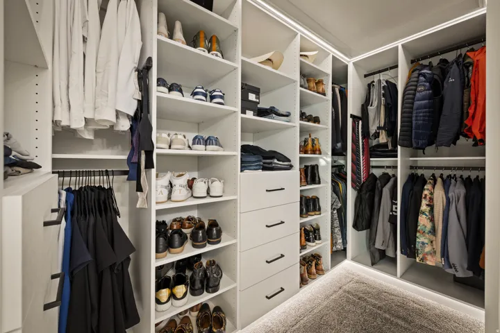Built-in closet system with multiple shelving units, hanging rods, and integrated drawers