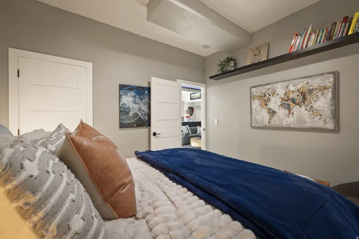 Recessed ceiling beam with flush-mounted lighting, white solid core doors, and a built-in wall shelf