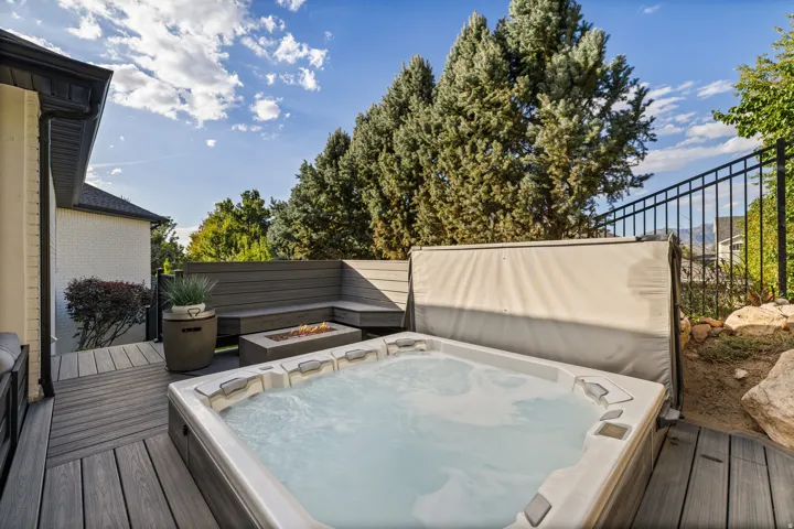 Outdoor deck with a built-in hot tub, composite decking, and integrated bench seating