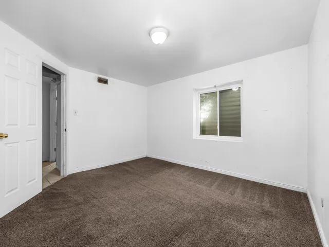 White walls, recessed window, brown carpet, and a flush mount ceiling light fixture