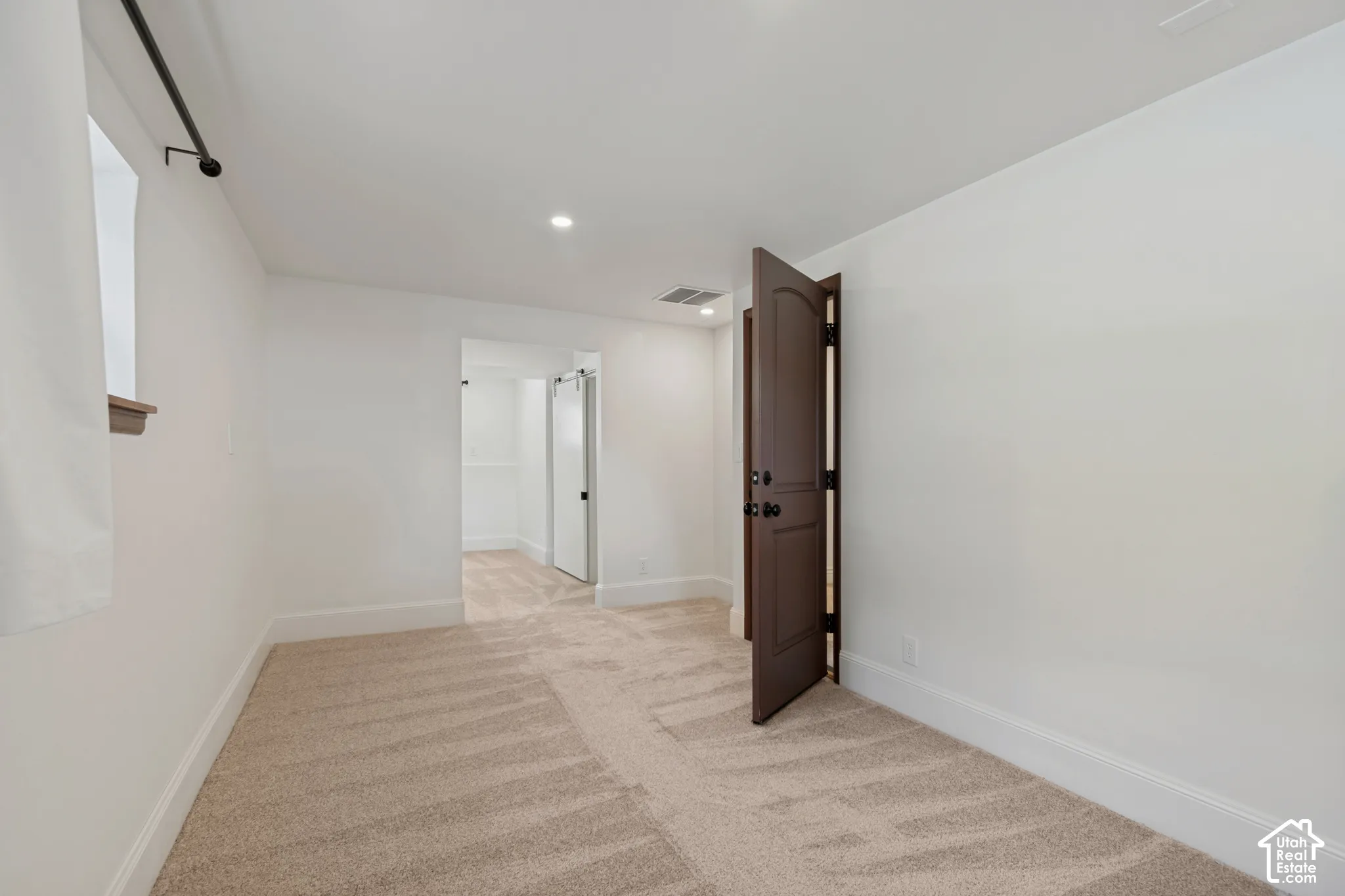 Neutral carpet flooring and white walls. Large bedroom.