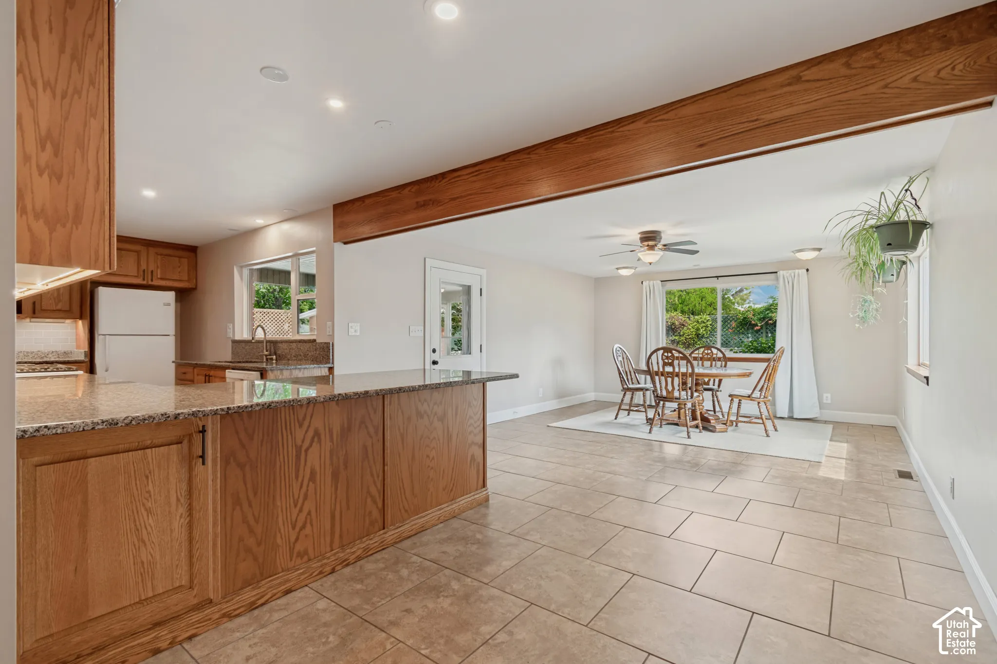 Open concept kitchen with wood-finish cabinetry, granite countertops, and recessed lighting