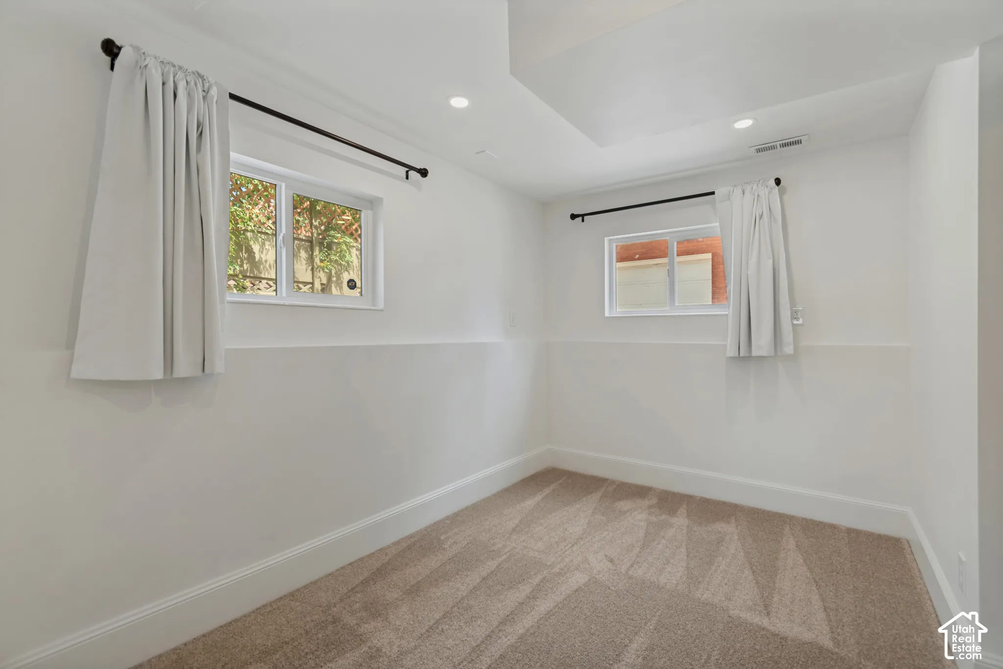 Recessed lighting, light-toned carpeting, and white walls. Basement bedroom 2 with an attached den/gaming room/office