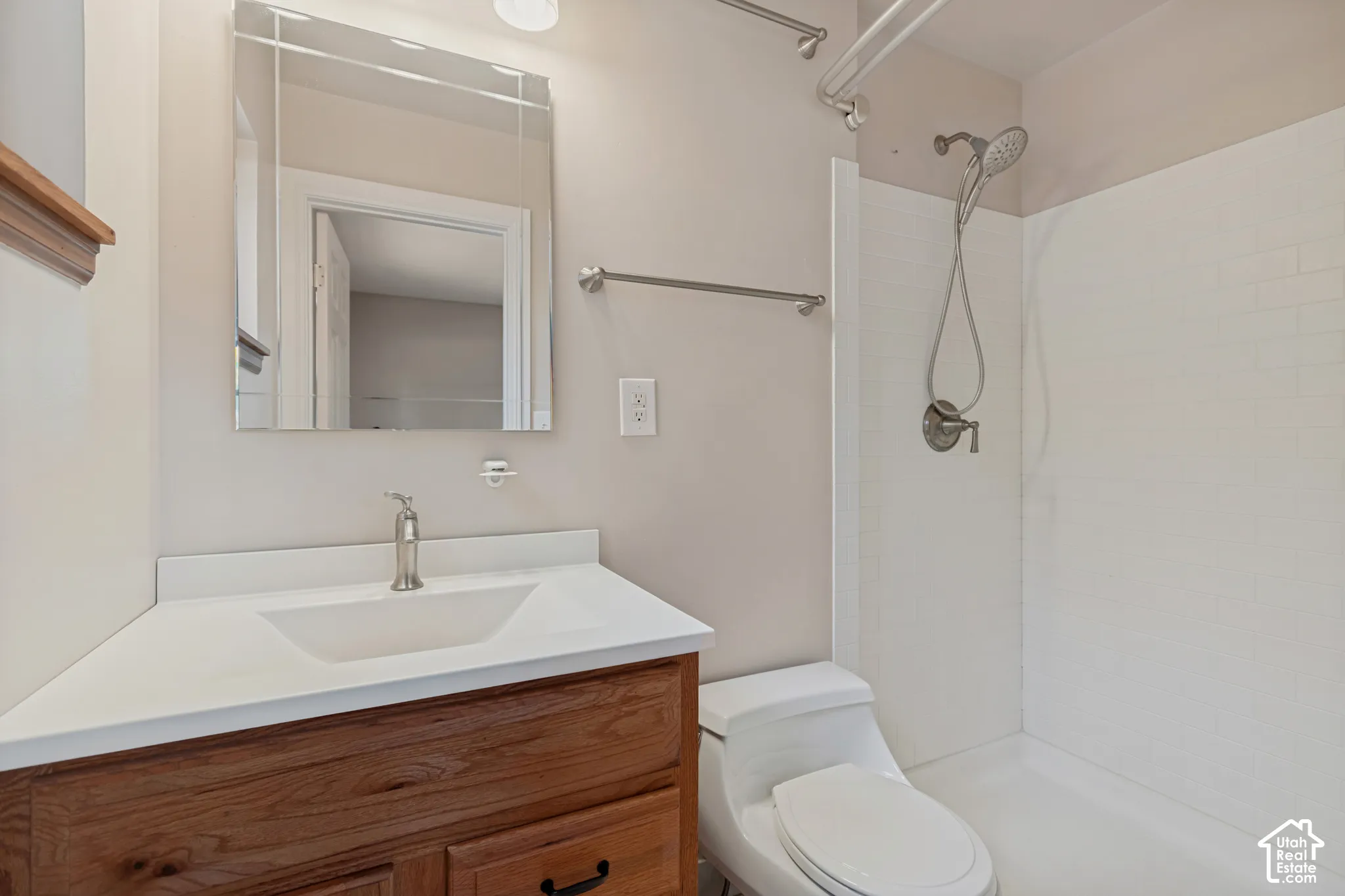 Wood-finish vanity with an integrated sink, polished chrome faucet, and a medicine cabinet mirror