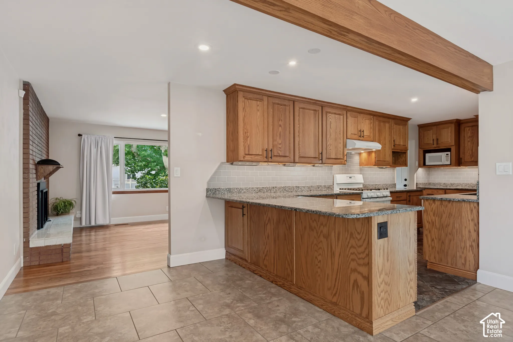 Kitchen featuring wood cabinetry, granite countertops, tile backsplash, and recessed lighting. Plenty of room to sit at the counter