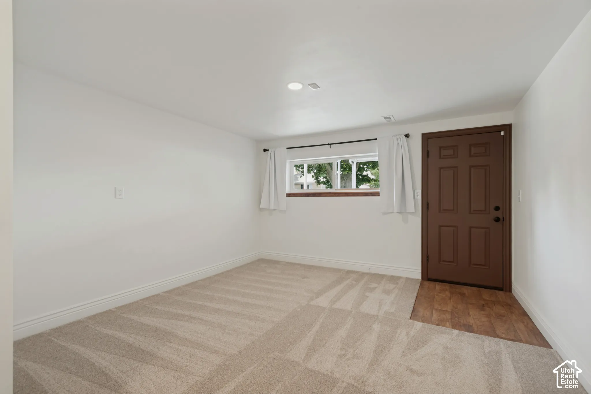 Neutral-toned carpeting, white walls, and a window with exterior views. Mother-In-Law private entrance to the entry and family room.