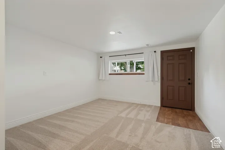 Neutral-toned carpeting, white walls, and a window with exterior views. Mother-In-Law private entrance to the entry and family room.