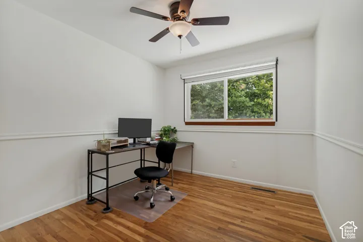 Hardwood flooring, white walls, and a multi-pane window with wood trim