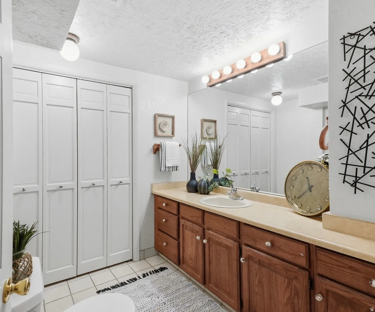 Vanity with integrated sink, wood-finish cabinetry, and a full-width mirror