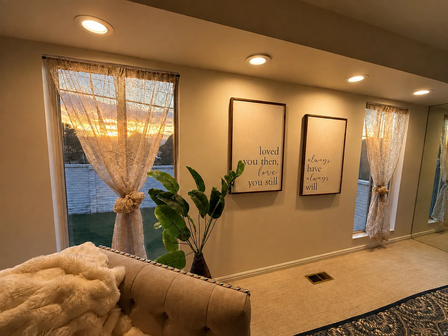 Recessed ceiling lighting, multiple large windows, wall-to-wall carpeting, and a full-height mirrored wall