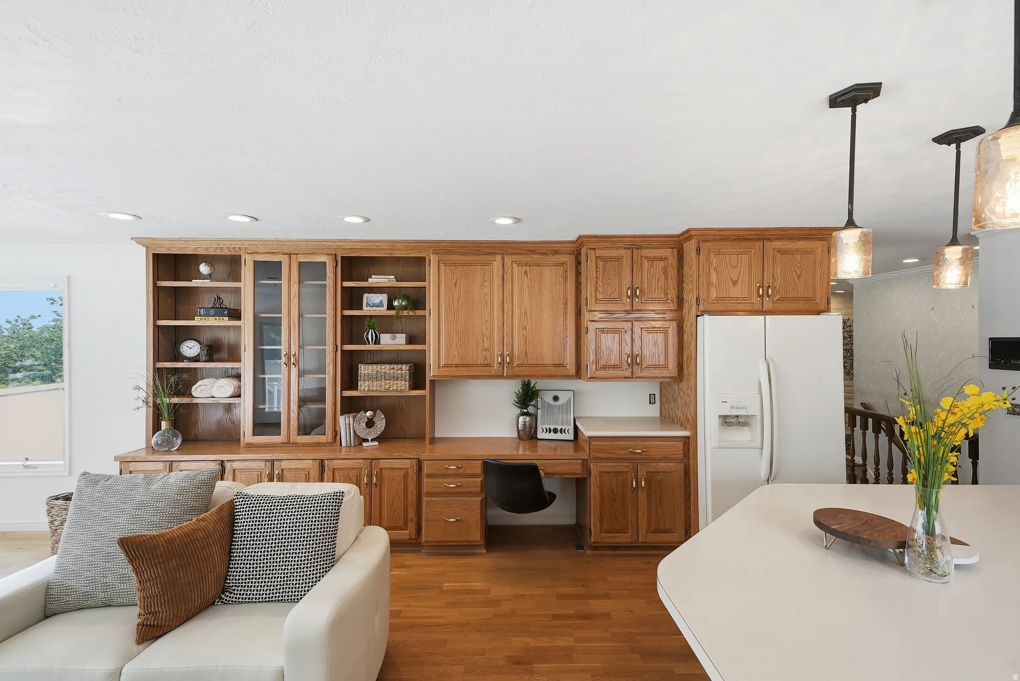 Built-in oak cabinetry and shelving with glass-front accents