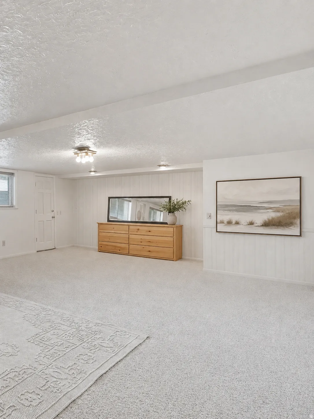 Spacious room featuring light-toned carpeting and multiple ceiling-mounted light fixtures