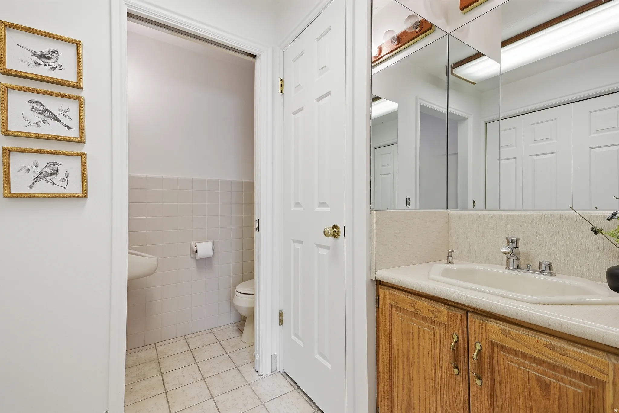 Vanity with wood-finish cabinetry, integrated sink, and mirrored medicine cabinet