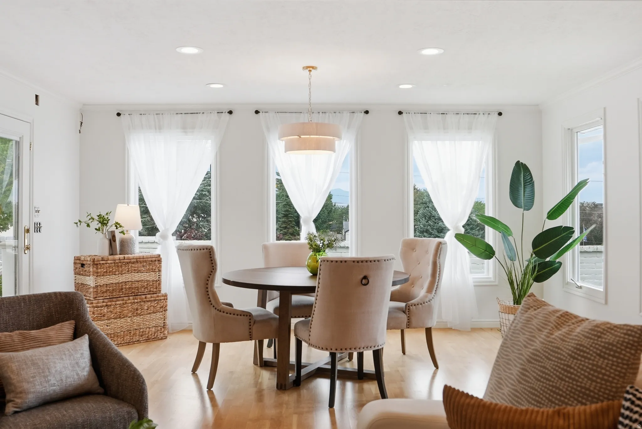 Recessed lighting, wood-finish flooring, multiple windows, and a multi-tiered chandelier