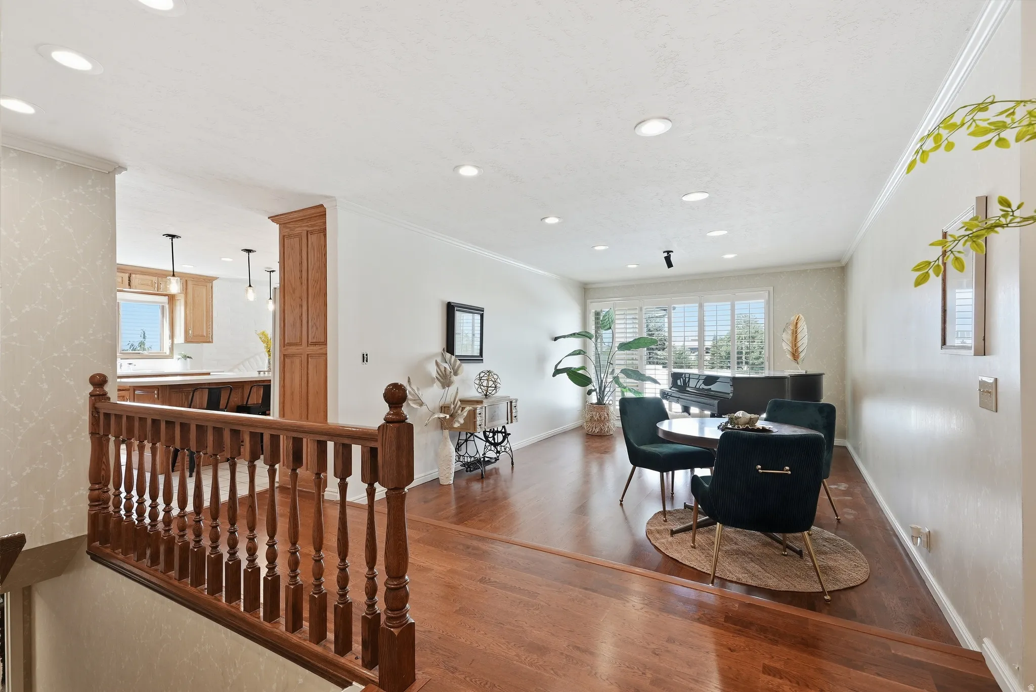 Hardwood flooring throughout, recessed lighting, crown molding, plantation shutters, and a kitchen with wood cabinetry and pendant lighting