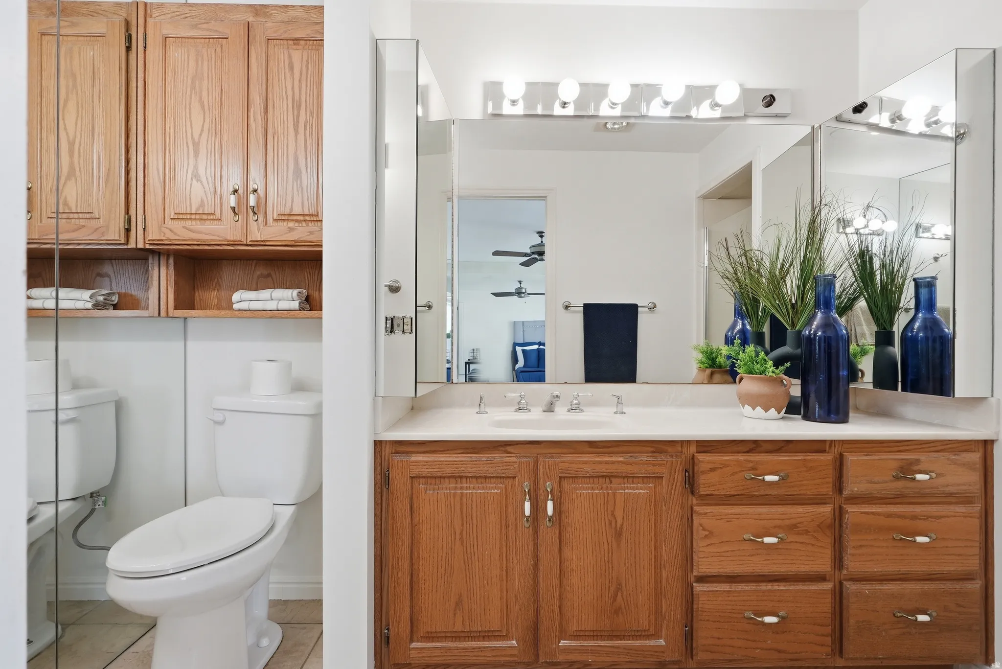 Primary Bathroom vanity with wood-finish cabinetry, integrated sink, and wall-mounted mirrors