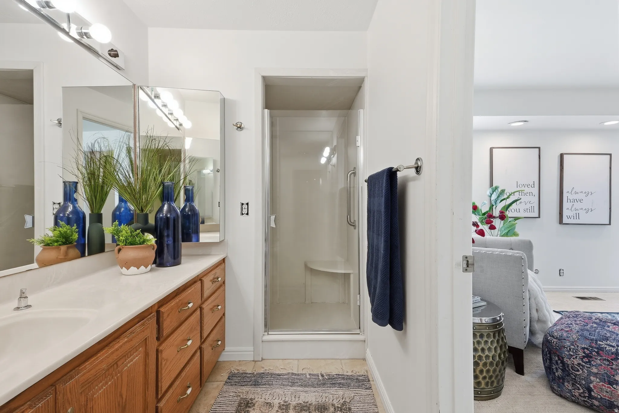 Primary Bathroom with single-sink vanity with wood-finish cabinetry, a light-toned countertop, and a mirrored medicine cabinet