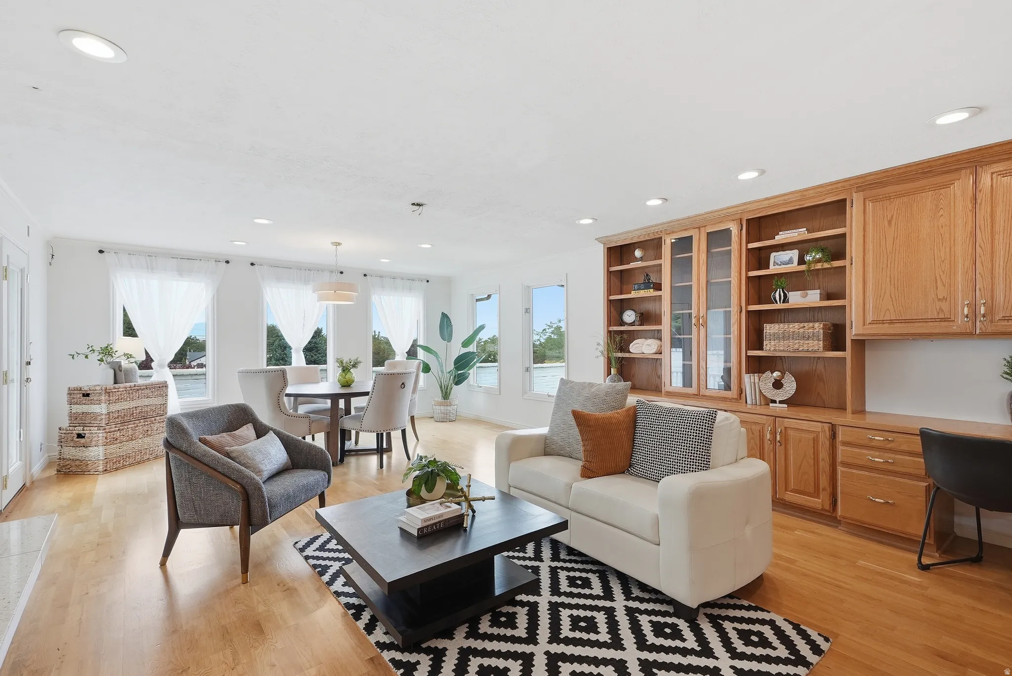 Hardwood-finish flooring throughout, recessed lighting, and built-in cabinetry with glass-front storage