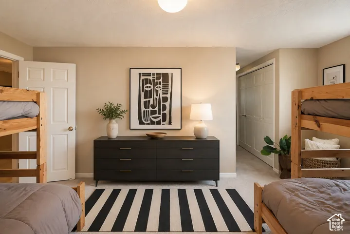 Carpeted flooring throughout, neutral wall tones, and a paneled interior door