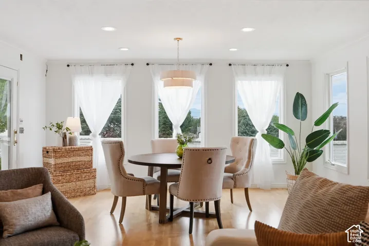 Recessed lighting, wood-finish flooring, multiple windows, and a multi-tiered chandelier