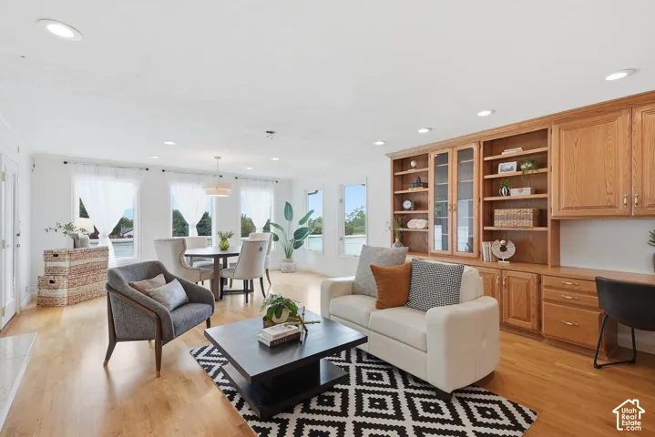 Hardwood-finish flooring throughout, recessed lighting, and built-in cabinetry with glass-front storage