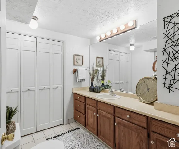Vanity with integrated sink, wood-finish cabinetry, and a full-width mirror