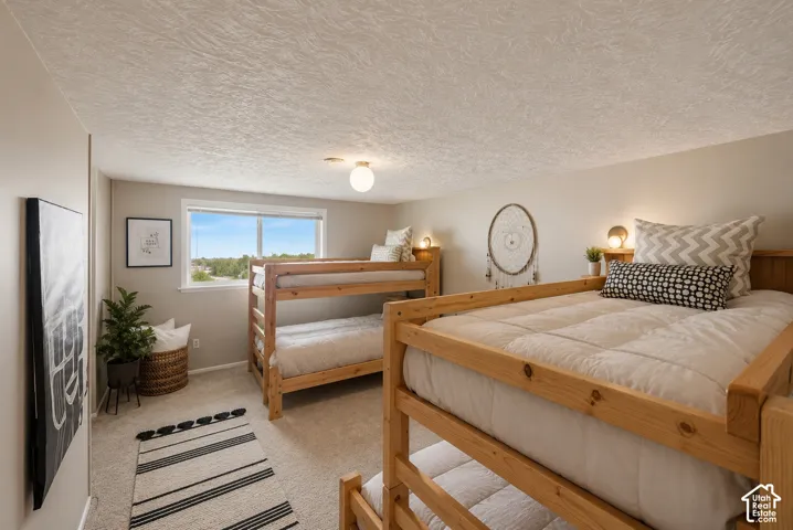 Carpeted room with a horizontal window and two wooden bunk beds