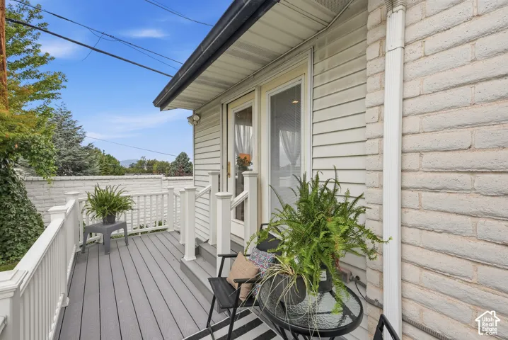 Outdoor deck with composite decking, white railing, and white siding