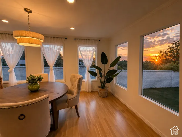 Hardwood flooring, recessed lighting, tiered chandelier, multiple windows, and crown molding