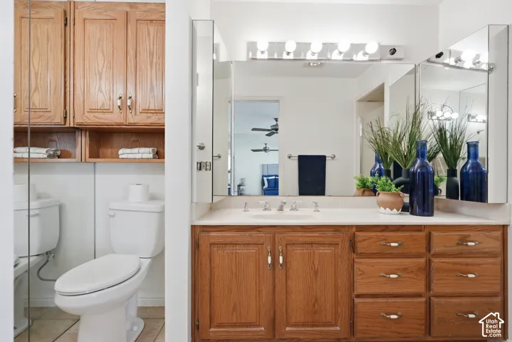Primary Bathroom vanity with wood-finish cabinetry, integrated sink, and wall-mounted mirrors