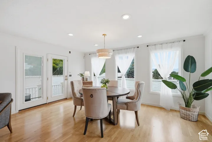 Hardwood-finish flooring, recessed lighting, and a tiered drum pendant light fixture illuminate the dining area