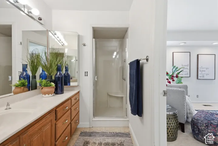Primary Bathroom with single-sink vanity with wood-finish cabinetry, a light-toned countertop, and a mirrored medicine cabinet