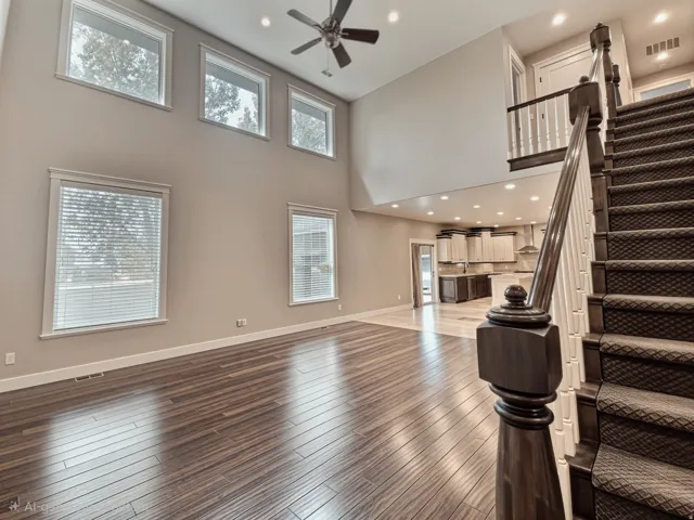 Two-story living area with picture windows an open floor plan and recessed lighting.