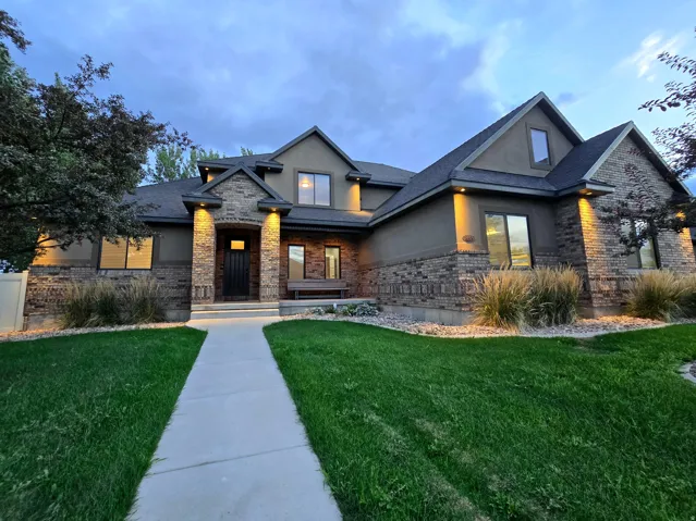 Brick and stucco exterior with stone accents, featuring a dark asphalt shingle roof