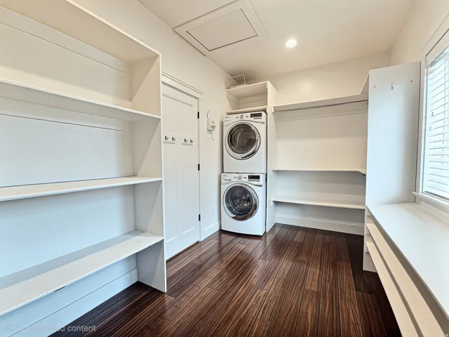 Primary Bedroom Closet featuring a large picture window, built in storage and a washer and dryer.