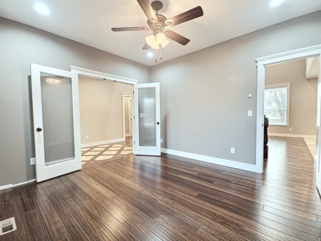 Vaulted ceiling featuring a ceiling fan, recessed lighting, french door entrance and wood flooring