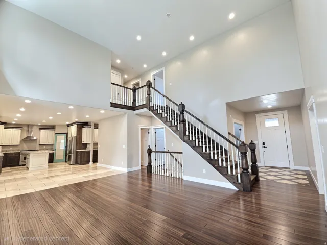 Two-story foyer with a grand staircase featuring dark wood newel posts and white balusters