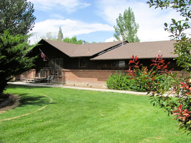 Wood-paneled exterior with brick foundation and a brown shingle roof