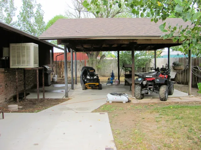 Covered patio with a shingled roof and concrete flooring