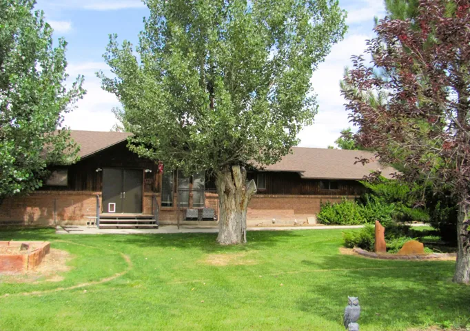 Brick and wood-sided exterior featuring a gable roof and mature trees
