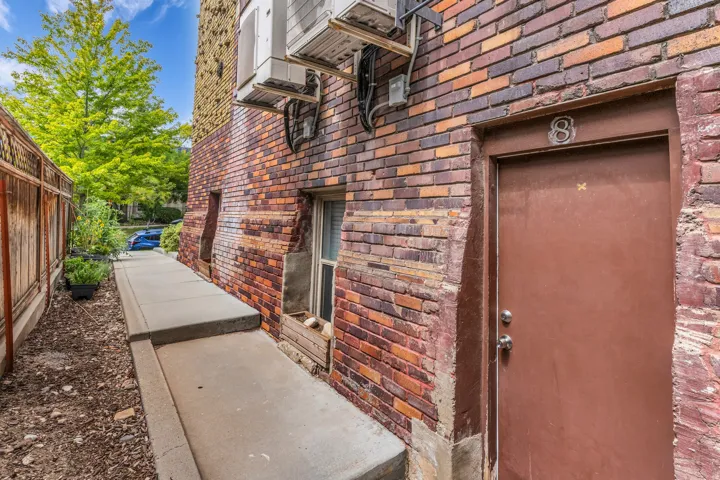 Brick exterior with a brown entry door featuring an address number