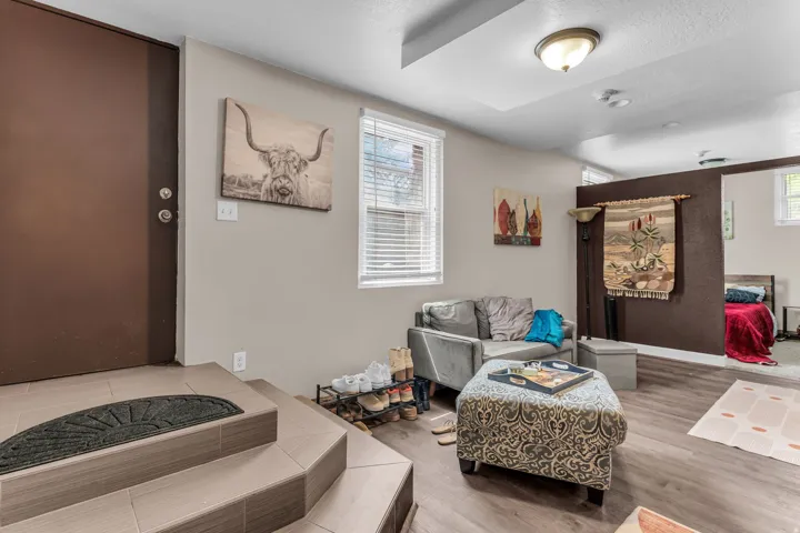 Wood-finish flooring, recessed lighting, and a defined entry area with tiled steps