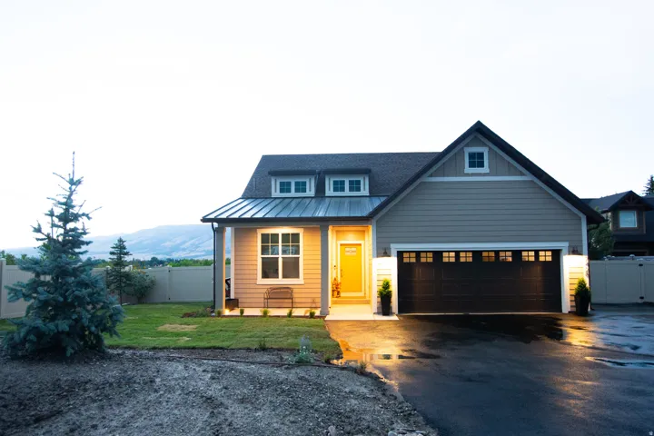 Modern farmhouse exterior with tan siding and dark trim