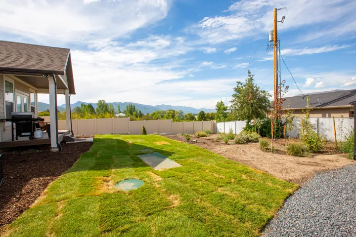 Covered patio with exterior lighting and a gravel pathway