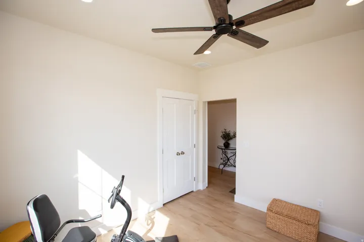 Flex Room with recessed ceiling lighting, wood-finish flooring, white paneled door, and a dark-toned ceiling fan