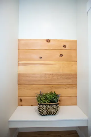 Built-in white bench with wood-paneled accent wall