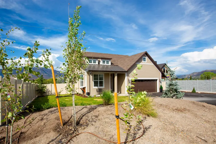 Contemporary home featuring a tan exterior, brown garage door, and light brown roofing