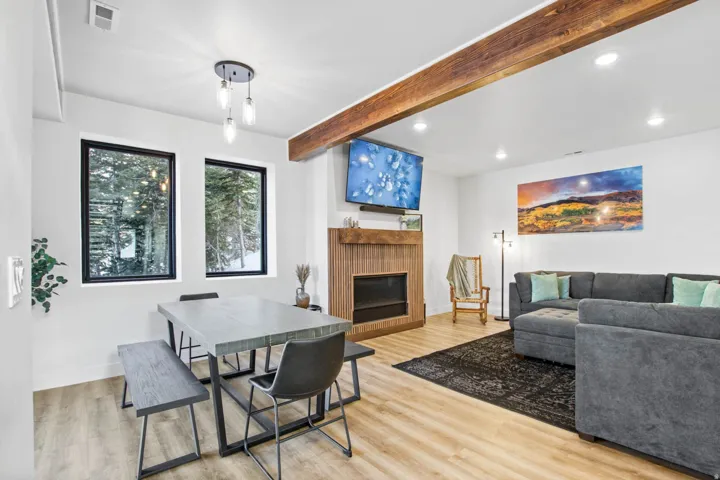 Wood-finish flooring throughout, recessed lighting, and exposed ceiling beam
